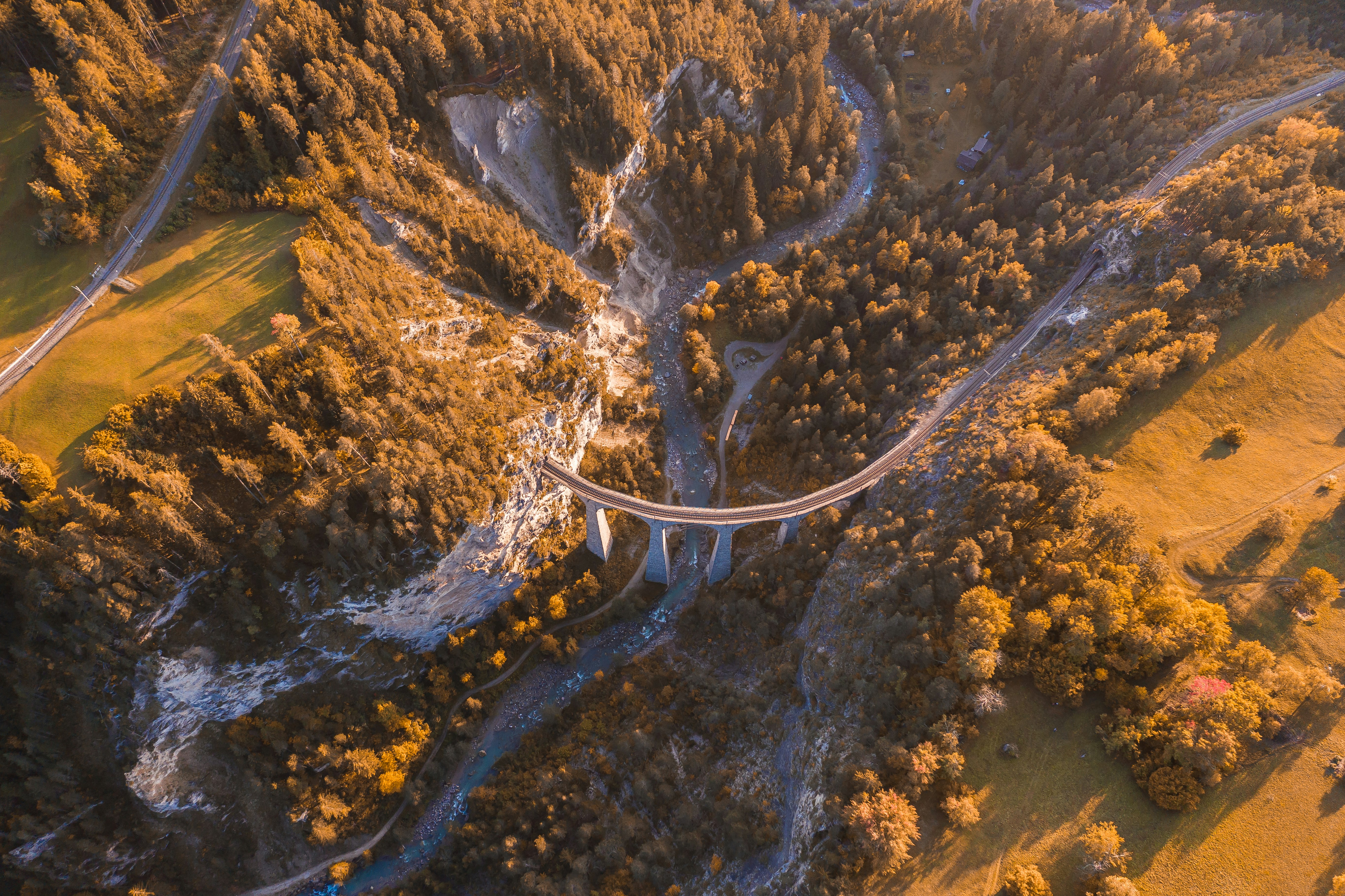 aerial photography of a concrete bridge and green mountains